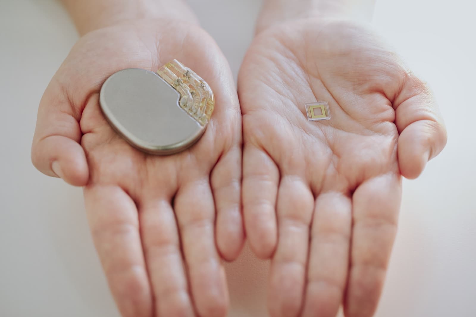 A conventional implant beside a Primoceler-packaged miniature device showing the scale difference
