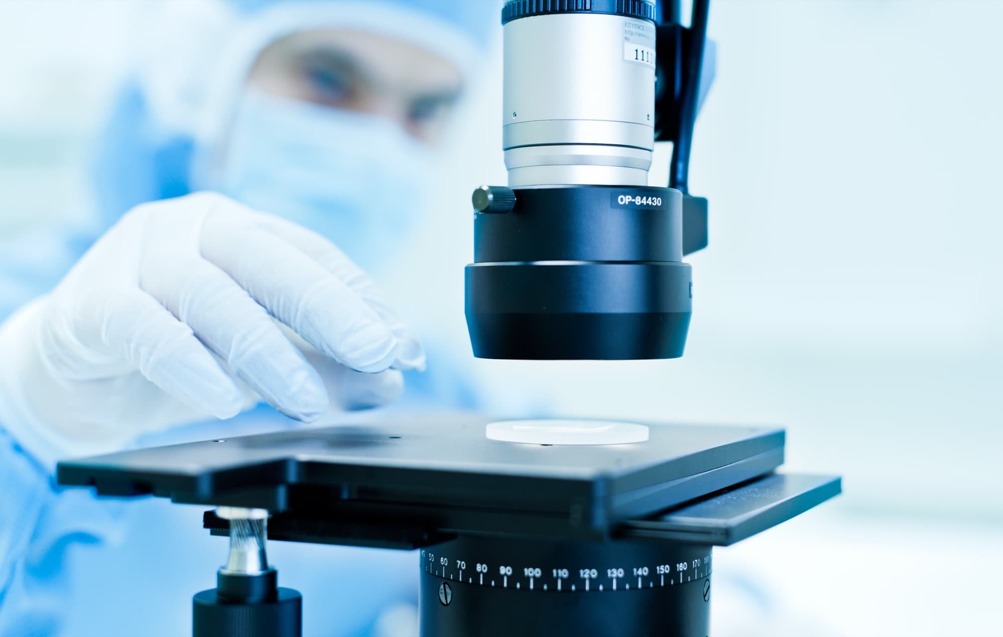 A glass sample being inspected under a microscope in the cleanroom